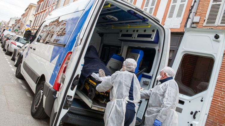 Des ambulanciers prennent en charge un cas présumé de Covid-19 dans le centre de Montauban le 6 avril 2020. (PATRICIA HUCHOT-BOISSIER / HANS LUCAS)